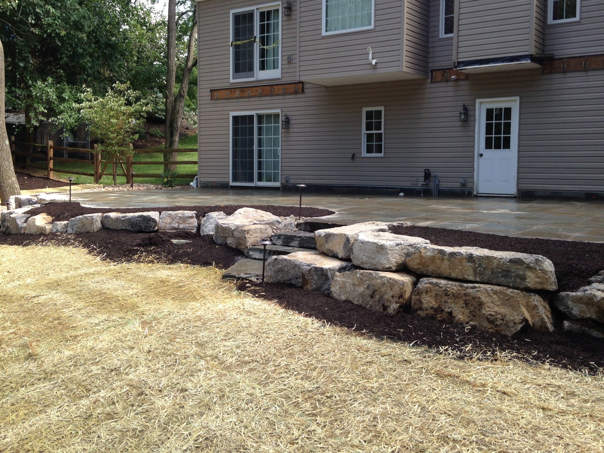 New landscaping, a large rock retaining wall, and mulch