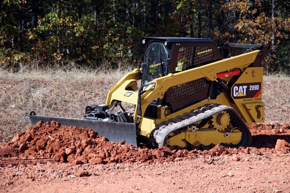 A Cat 289D compact track loader grading dirt
