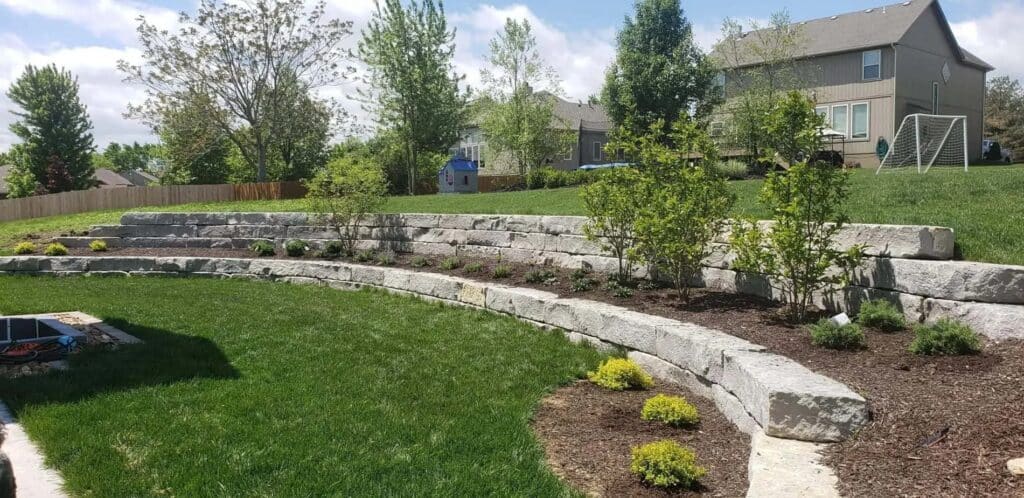 A tiered retaining wall made from large boulders