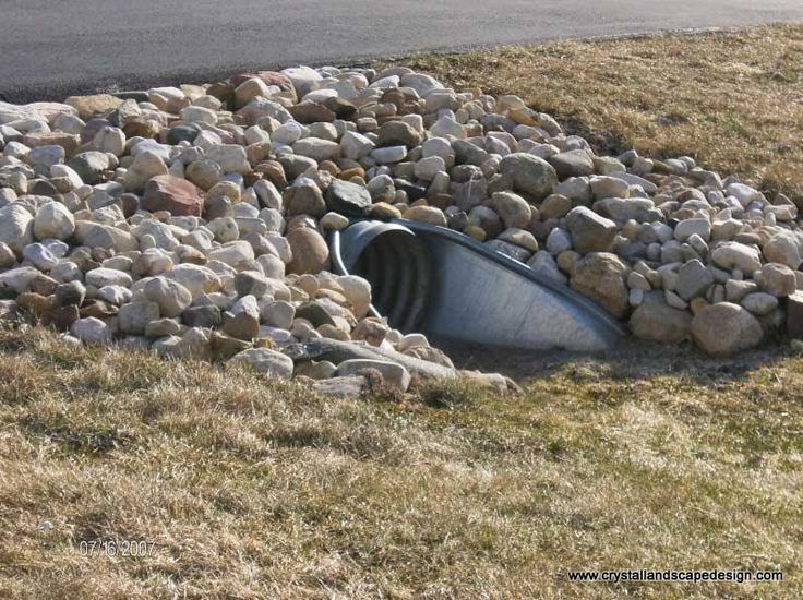 A galvanized steel culvert surrounded by rocks