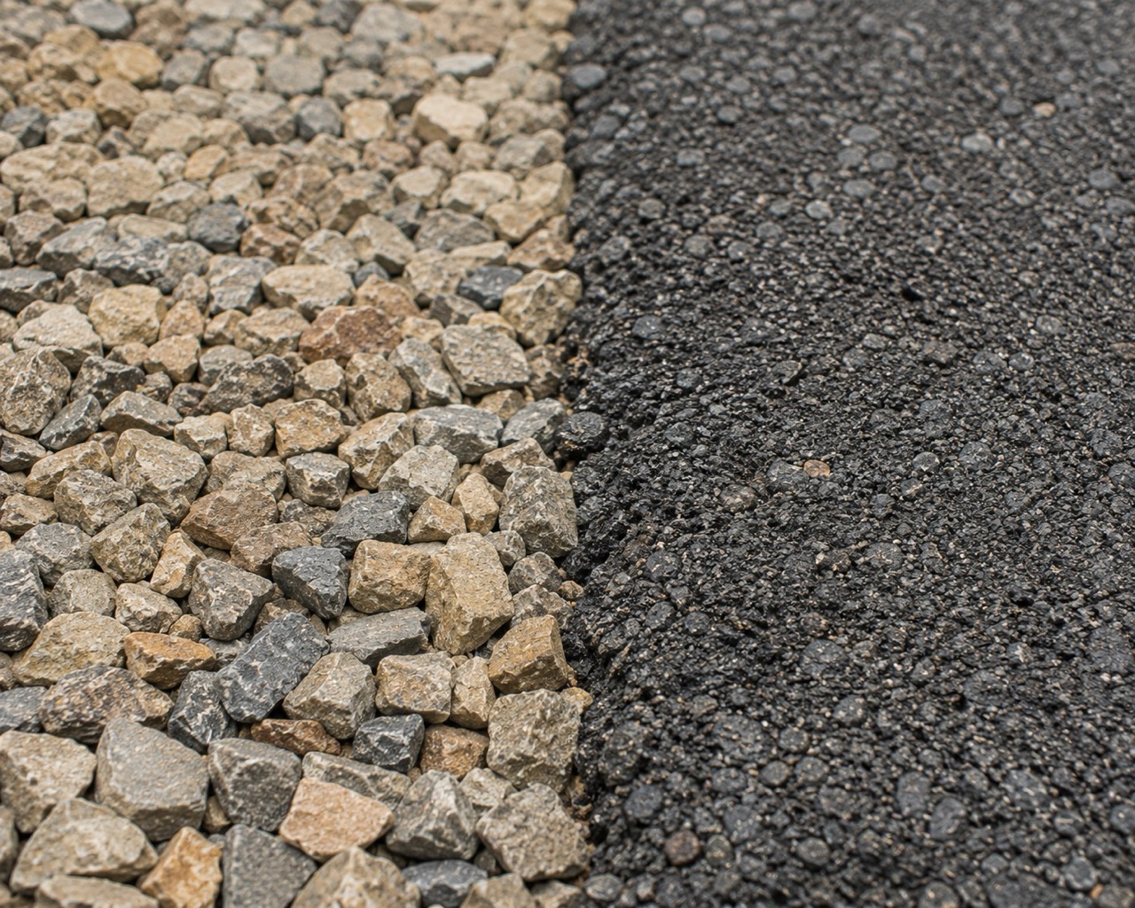 Close-up showing gravel versus new asphalt road.